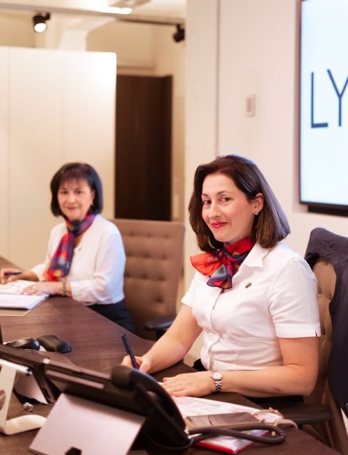 twee receptionistes achter desk lachen